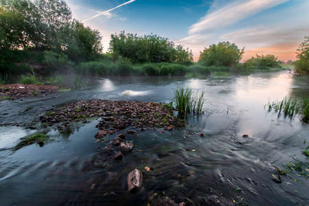 Summer sunrise over the river. Calm, relaxing rural landscape.の写真素材
