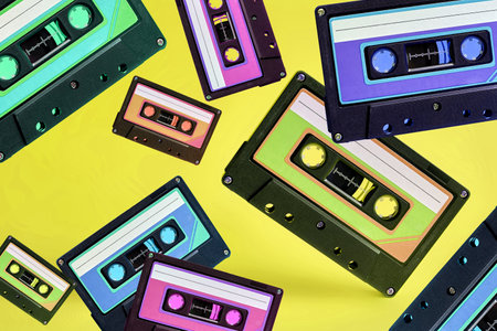 Pop music style attributes eighties, retro old school concept. Multicolored audio cassette levitates...