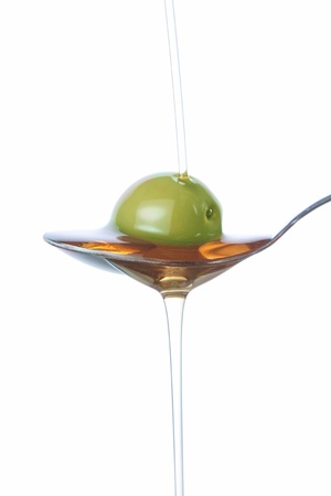 Olive on the spoon, pouring with oil の写真素材