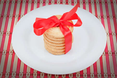 Christmas cookies in a plate with a bow on a napkin.の写真素材
