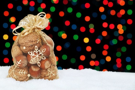 Christmas present in the snow on a background of colored bokeh の写真素材