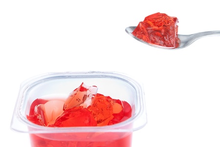 Spoon full of red gelatin  Against the background of the package 