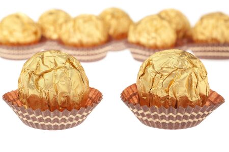 Group chocolate candies wrapped in gold. On a white background.の写真素材