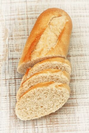 Sliced â€‹â€‹pieces of fresh bread on the board texture. Close-up.