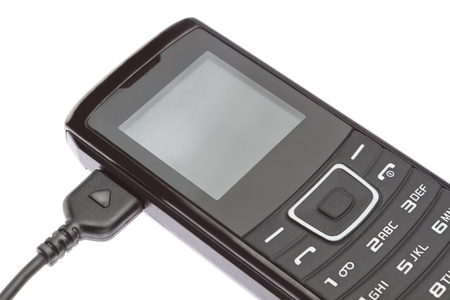 Mobile phone while charging  On a white background の写真素材