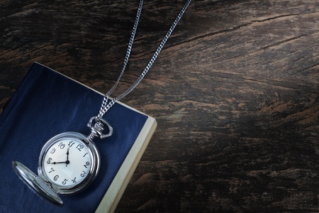 Pocket watch on an old book, a notebook on wooden texture  Concept の写真素材