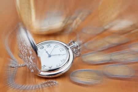 Pocket watch against the background of the euro coins, in focus 