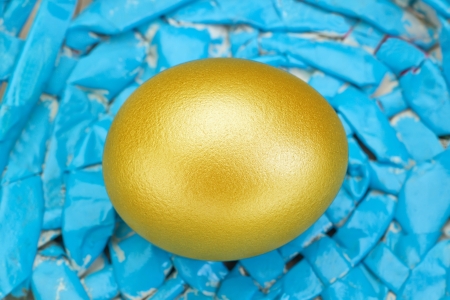 Golden easter egg on blue background.の写真素材