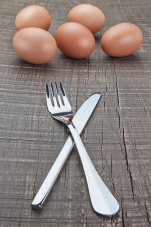 Cutlery fork and knife and Easter eggs. On a wooden texture.の写真素材