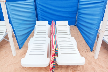 Sun loungers on the sand, and fencing for the wind.の写真素材