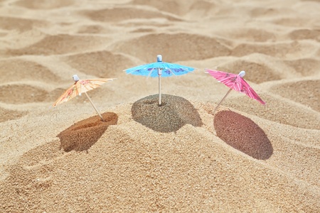 Small beach umbrellas on the beach near the sea.の写真素材