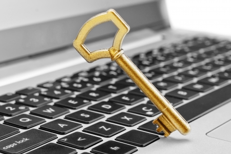 Golden key symbol of security in Internet and computer science. On the laptop.