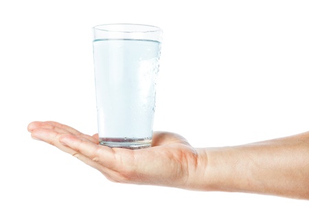 A glass of clean and fresh water in the hand of man. On a white background.
