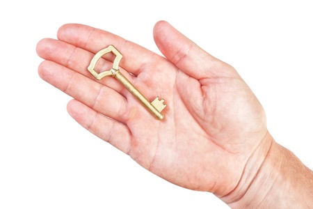 Golden key in the palm of a man's symbol of wealth. On a white background.の写真素材
