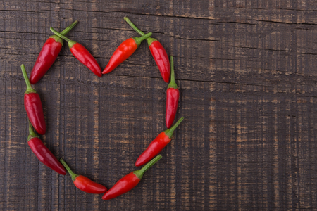 Paprika red pepper in the shape of heart. The texture on a wooden table . Valentine's Day.の写真素材