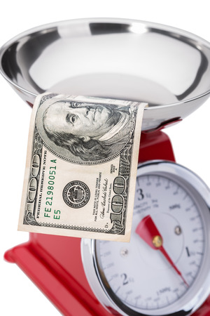 The significance of the dollar in the economy. One hundred dollars on the scales.の写真素材