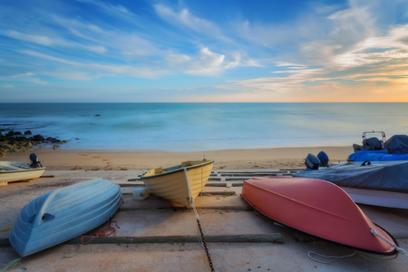 Three colorful boats resting on the shore. On the background a sea landscape.の写真素材