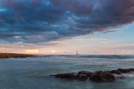 Dramatic landscape sailboat before the storm. Gale Beach Albufeira.の写真素材