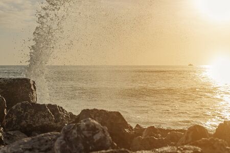 Sunset and waves splashing on the beach.の写真素材