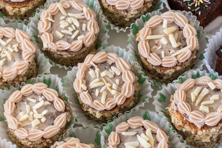 Cream cakes in paper baskets. Close-up on birthday.の写真素材