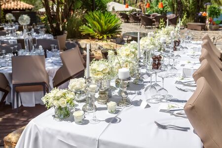 Decorations of the wedding table with flowers and dishes.