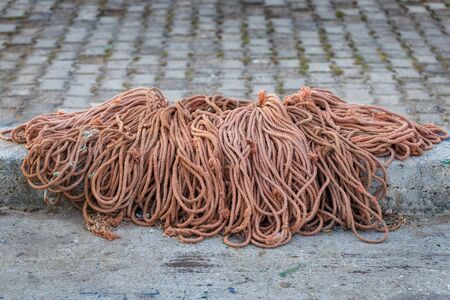 Pile of rope on asphalt for fishermens networks.の写真素材