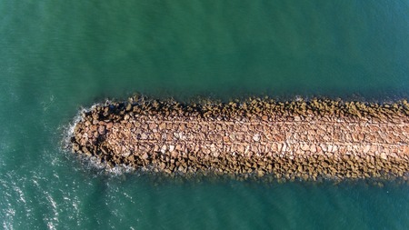 Aerial. Breakwater on the Guadiana River in city Vila Real Santo Antonio. Portugalの写真素材