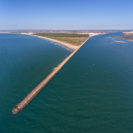 Aerial. Breakwater on the Guadiana River in city Vila Real Santo Antonio. Portugalの写真素材