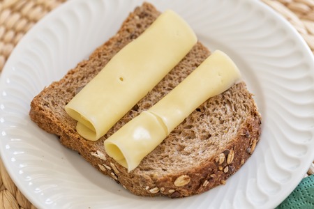 Morning breakfast of Dutch cheese and black bread. Close up