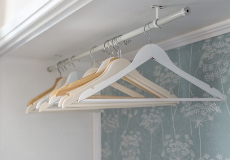 Hanger hanging in a wardrobe. Close-up in wite.の写真素材