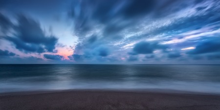Dramatic long exposure seascape on the beach of Faro, Portugal.