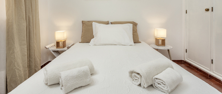 Modern bedroom with pillows and a bed for tourists. Frontally.
