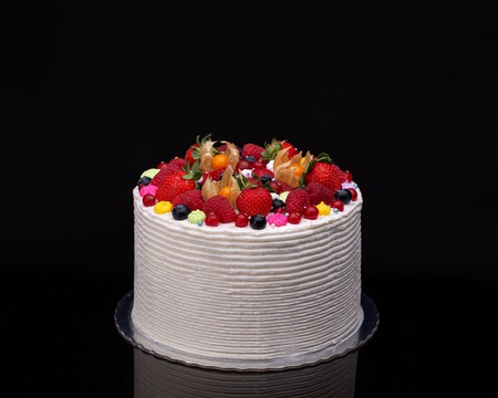 Delicious birthday fruit cake for dessert, black background.の写真素材