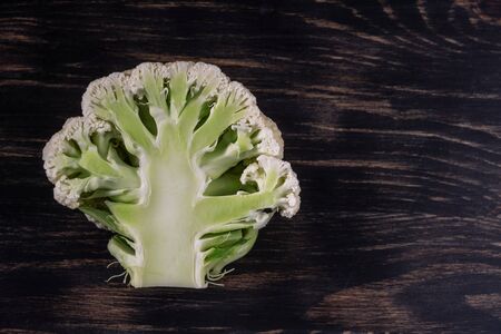 Cauliflower on a wooden dark background, closeup. For vegetarianism. Copy space.の写真素材