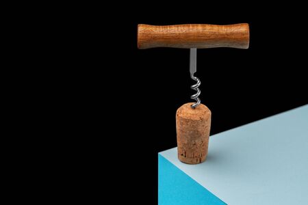 Corkscrew with a cork for wine on a three-dimensional plane. On a cube on a black background.の写真素材