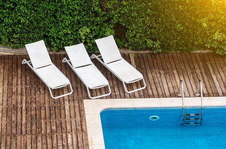 Pool with sun beds and umbrella for tourists at the hotel. Sunny day.