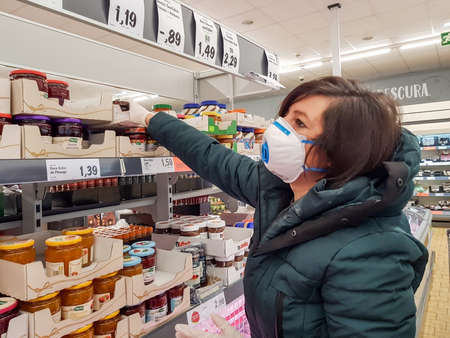Portugal Faro 2020 8 - April: woman in a supermarket Lidl, shopping cart during the coronavirus period makes purchases of essential products.のeditorial素材