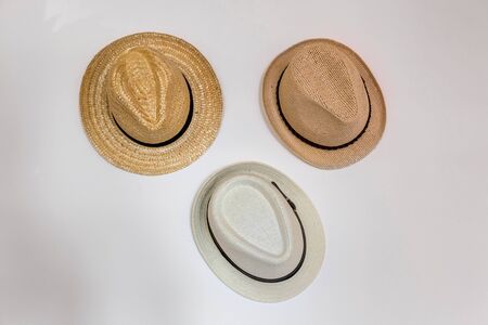 Headdress straw hats, beige and white panama hanger hanging on a gray wall in a horizontal position.の写真素材