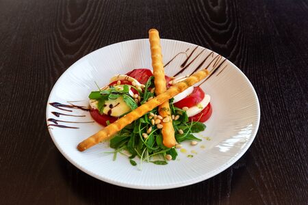 Caprese salad with buffalo mozzarella. Dark background. Close-up