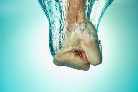 Man hit the water, the concept of strength and self-confidence, assertiveness and success. Close up on a blue background. from above.の写真素材