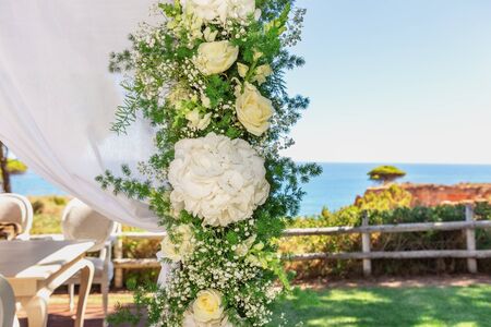 Beautiful wedding bouquet in a tulle, tied with a ribbon, on the background of the ocean. Close-up.の写真素材