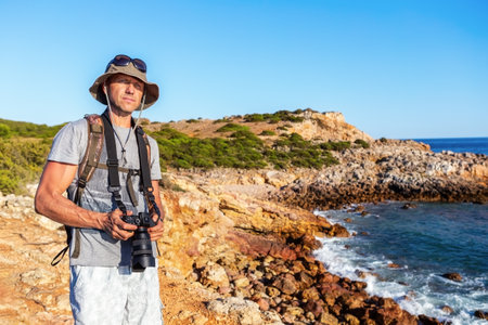 Male photographer traveler with a camera on the seashore, portrait. High quality photoの写真素材