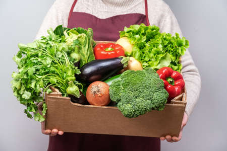 Middle aged woman volunteer delivers food and vegetables to people in quarantine. Home insulation...