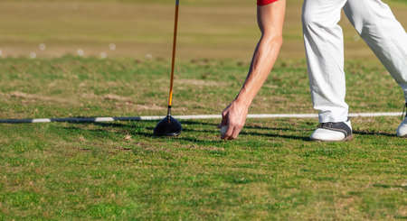 Waist down shot of golfer placing a golf ball to get ready for a new game. High quality photoの写真素材