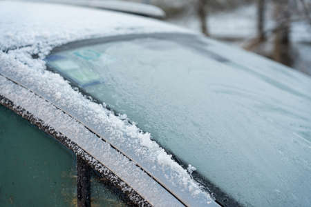 Car covered with ice and icicles after freezing rain. Ice covered car window close up. Bad winter...