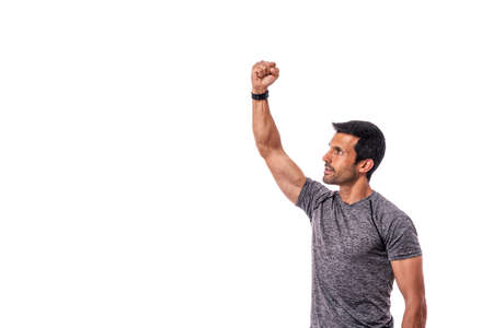 A middle-aged man of athletic build with a raised hand up. Fight. Copy space. Isolated on a white background. High quality photoの写真素材