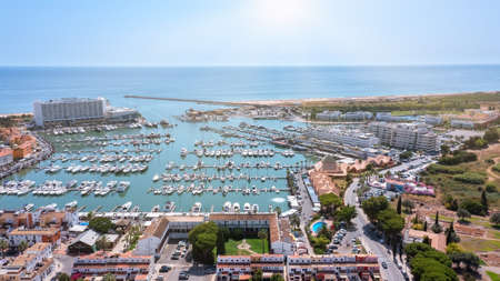A view from the sky of the tourist Portuguese town of Vilamoura, with Yachts and sailboats moored in the port on the dock. High quality photoの写真素材