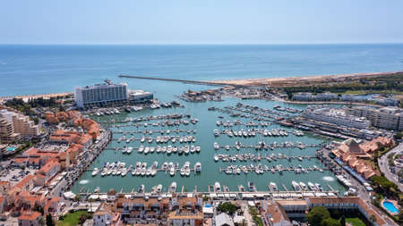 A view from the sky of the tourist Portuguese town of Vilamoura, with Yachts and sailboats moored in the port on the dock. High quality photoの写真素材