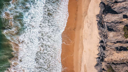 Aerial view of crashing waves on beach and rocks. Aerial view of sea waves and turquoise water and waves. High quality photoの写真素材