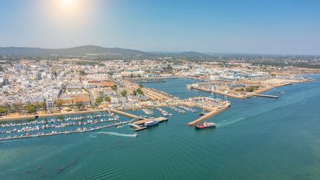 Aerial view of Portuguese fishing tourist town of Olhao with a view the Ria Formosa Marine Park. Sea port for yachts. Sun over moun Cerro san miguelの写真素材